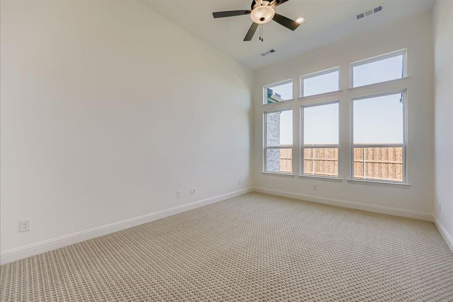 Carpeted empty room with baseboards and a ceiling fan