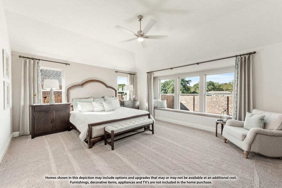 Spacious master bedroom with vaulted ceiling, ceiling fan, window seat, and neutral carpet