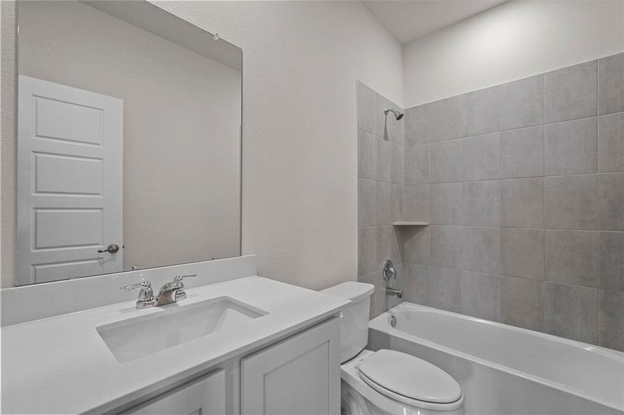 Full bathroom featuring vanity, toilet, and tiled shower / bath combo