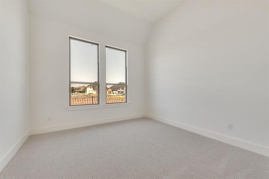 Spare room with light carpet and vaulted ceiling Spare room with light carpet and vaulted ceiling