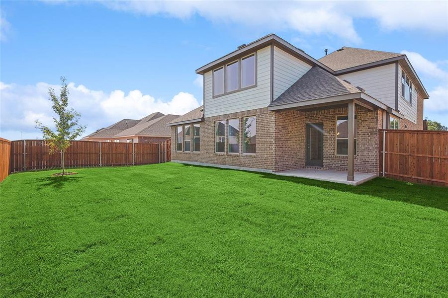 Back of property featuring a yard and a patio