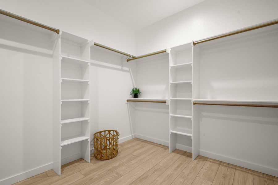 Walk in closet with light wood finished floors