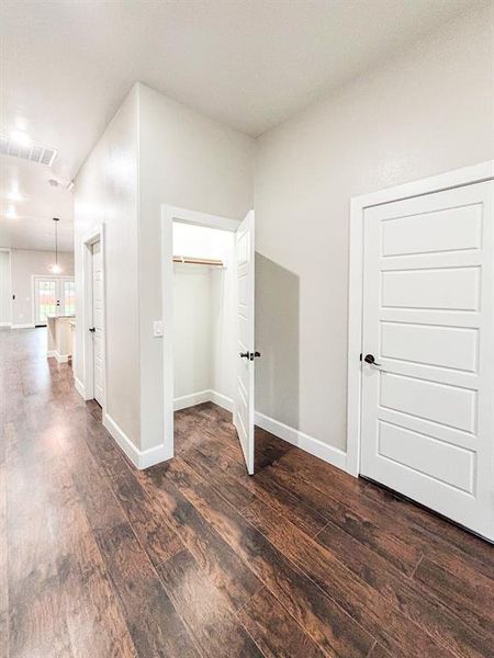 Corridor with dark wood-type flooring and baseboards Corridor with dark wood-type flooring and baseboards