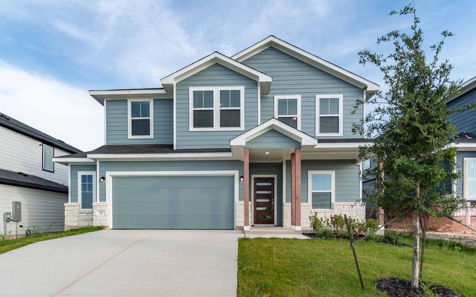 View of front of home featuring stone siding, driveway, an attached garage, and a front yard View of front of home featuring stone siding, driveway, an attached garage, and a front yard