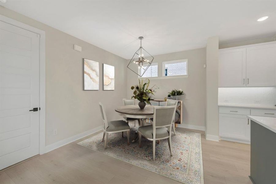 Dining area featuring light wood-style floors and a chandelier