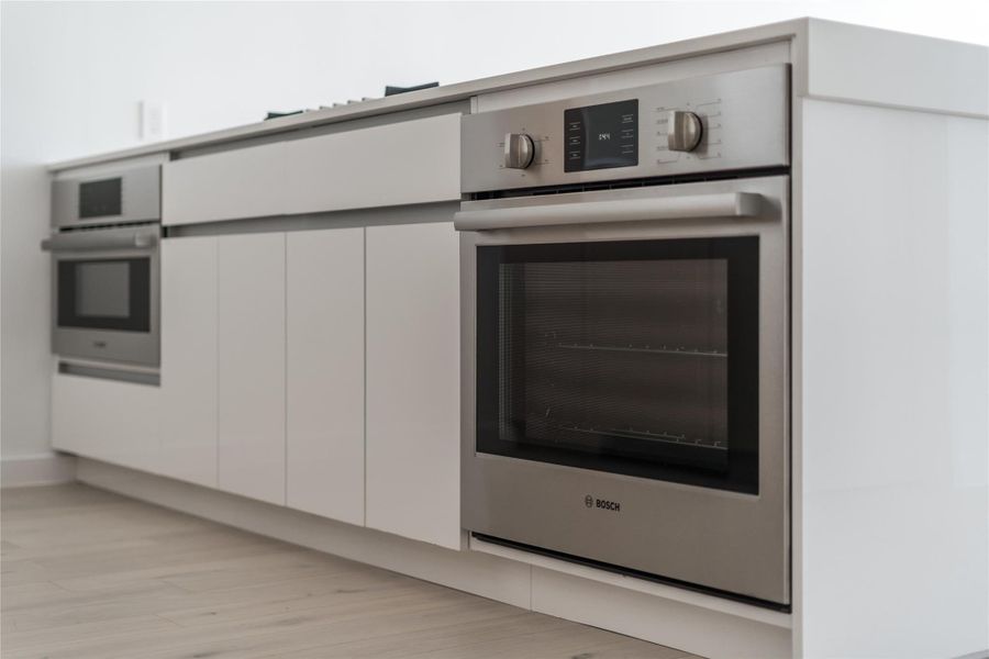 A sleek, integrated oven and microwave setup enhances this contemporary kitchen's clean lines. A sleek, integrated oven and microwave setup enhances this contemporary kitchen's clean lines.