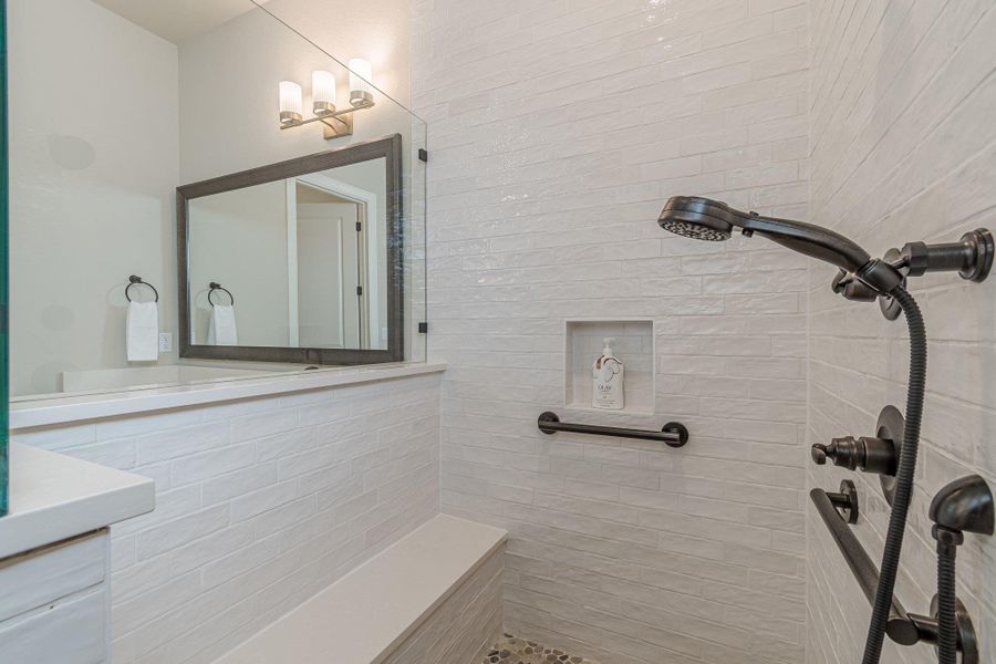 Bathroom featuring a tile shower and vanity