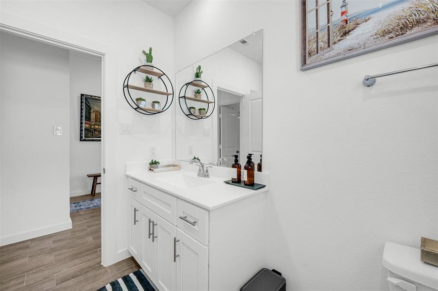 Bathroom with vanity, toilet, and hardwood / wood-style floors