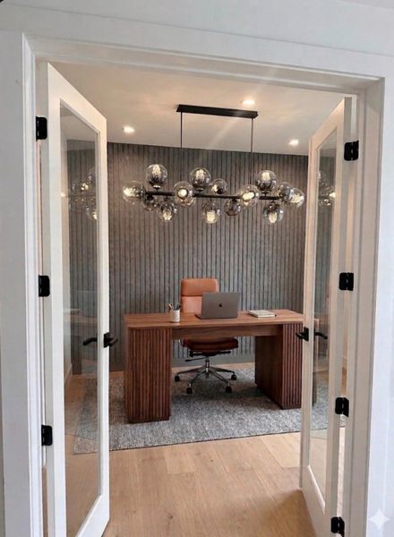 Main-level study/home office with a custom accent wall, modern lighting, and French doors. Virtually staged. Main-level study/home office with a custom accent wall, modern lighting, and French doors. Virtually staged.