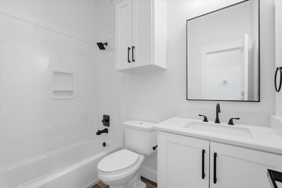A pristine second bathroom features a crisp white vanity paired with a matte black accesories. The shower-tub combo is framed by bright, clean finishes, making the space feel incredibly fresh and welcoming. A pristine second bathroom features a crisp white vanity paired with a matte black accesories. The shower-tub combo is framed by bright, clean finishes, making the space feel incredibly fresh and welcoming.