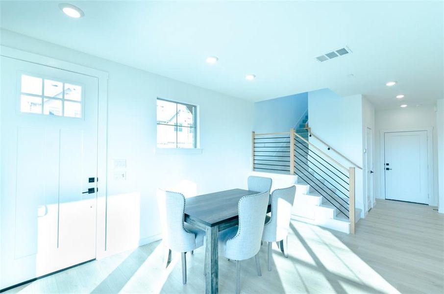 Dining space with stairway, light wood-type flooring, and recessed lighting