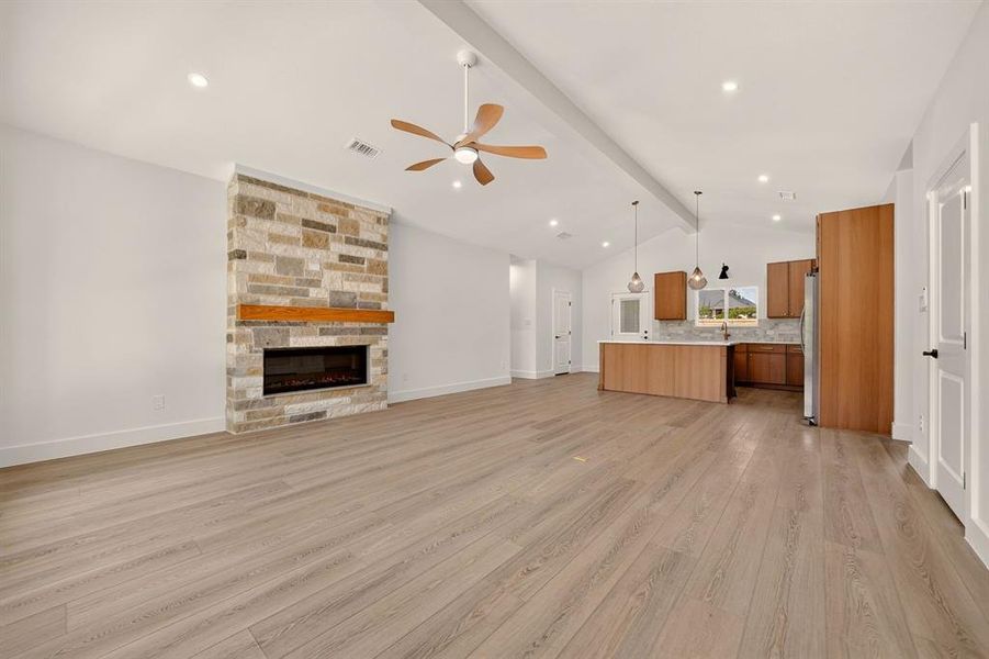 Vaulted ceilings above wood-finish flooring extending throughout the open-concept space