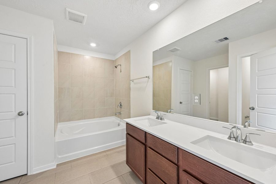 This stunning primary bathroom is truly move-in ready! It features stained cabinetry with light countertops, dual sinks, a large mirror, high ceilings, custom paint, and sleek modern finishes throughout. This stunning primary bathroom is truly move-in ready! It features stained cabinetry with light countertops, dual sinks, a large mirror, high ceilings, custom paint, and sleek modern finishes throughout.