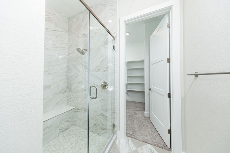 The walk-in shower includes a convenient, integrated white bench, offering comfort and a high-end, custom appearance. The walk-in shower includes a convenient, integrated white bench, offering comfort and a high-end, custom appearance.
