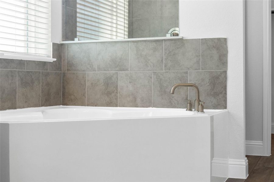 A large white soaking tub offers a perfect spot for relaxation. A large white soaking tub offers a perfect spot for relaxation.