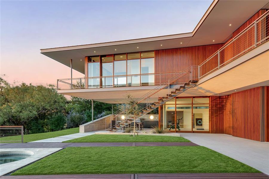 Outdoor living and kitchen with outdoor stairs and surrounding balcony.