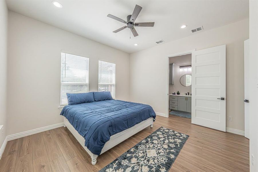 Bedroom with recessed lighting, light wood finished floors, ceiling fan, and connected bathroom Bedroom with recessed lighting, light wood finished floors, ceiling fan, and connected bathroom