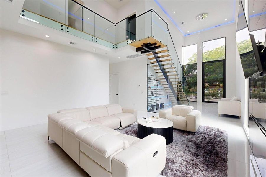 Tiled living area featuring a high ceiling, stairway, and recessed lighting Tiled living area featuring a high ceiling, stairway, and recessed lighting