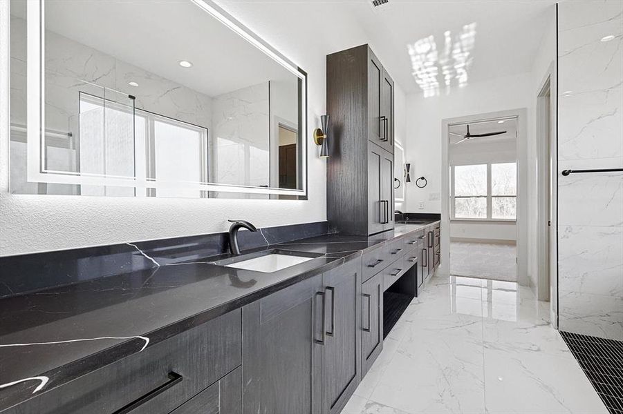 Bathroom featuring vanity and ceiling fan with notable chandelier