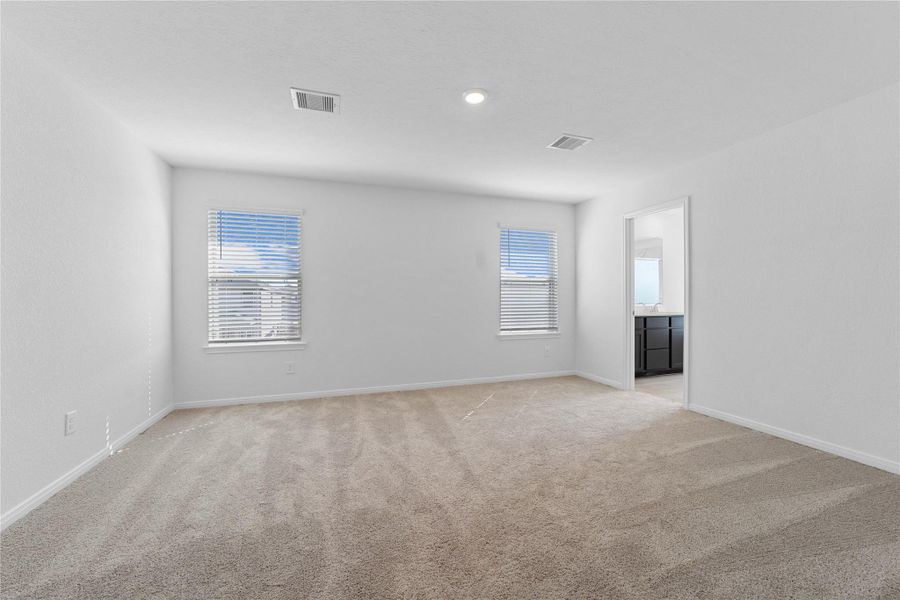 Relax and recharge in this stunning primary suite! This expansive room offers plush carpeting, neutral-toned walls, high ceilings, and large windows fitted with privacy blinds—perfect for unwinding after a long day.