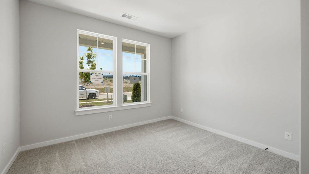 Spacious secondary bedroom with carpet and windows