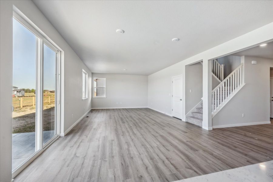 A large empty room with a wood floor and a glass door. A large empty room with a wood floor and a glass door.