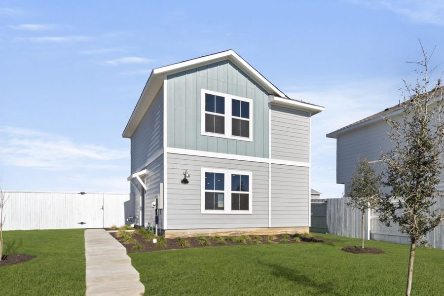 Image of the front exterior of a light blue two story cottage home with windows, white trim, a cement walkway to front door, green grass and a blue sky in the background Image of the front exterior of a light blue two story cottage home with windows, white trim, a cement walkway to front door, green grass and a blue sky in the background