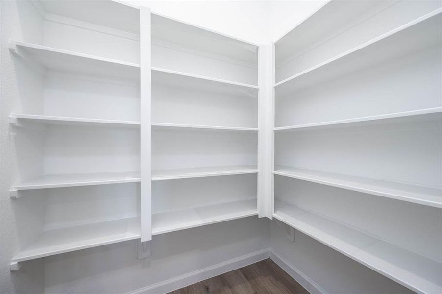 A walk-in pantry with custom shelving provides all the storage you need to keep your kitchen organized and clutter-free.