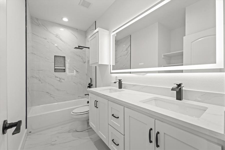 Full bathroom featuring vanity, toilet, and tiled shower / bath