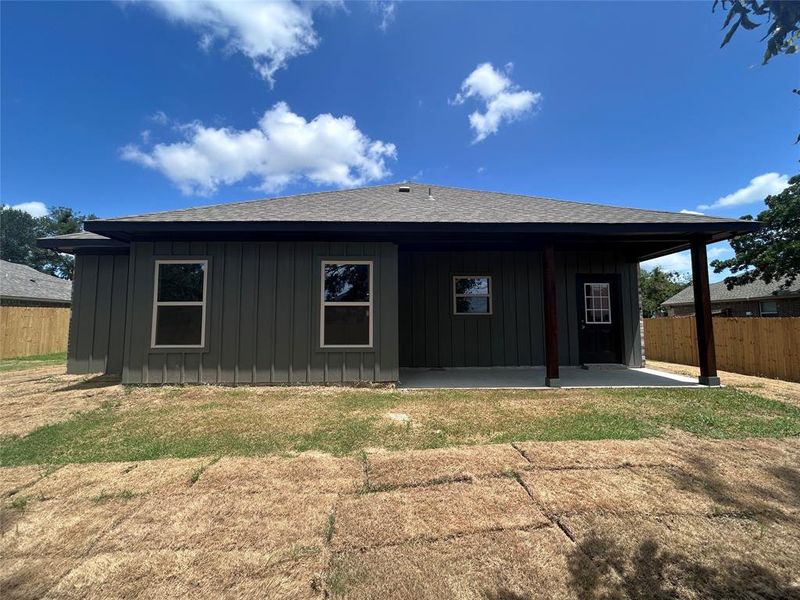 Back of property featuring board and batten siding, roof with shingles, and a patio Back of property featuring board and batten siding, roof with shingles, and a patio