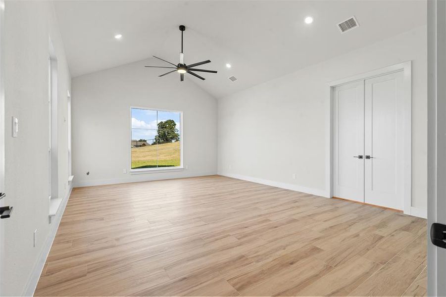 Unfurnished bedroom featuring light wood-type flooring, vaulted ceiling, ceiling fan, and recessed lighting Unfurnished bedroom featuring light wood-type flooring, vaulted ceiling, ceiling fan, and recessed lighting