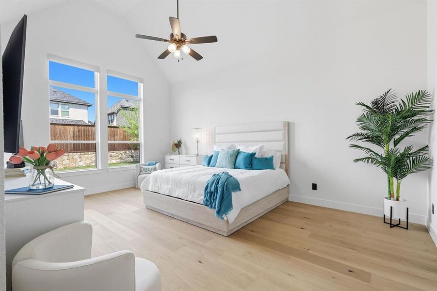 Primary Bedroom with light hardwood floors, ceiling fan, and high vaulted ceiling Primary Bedroom with light hardwood floors, ceiling fan, and high vaulted ceiling
