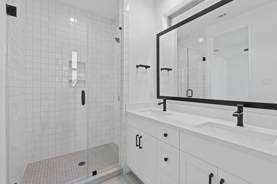 Full bathroom featuring a shower stall and double vanity Full bathroom featuring a shower stall and double vanity