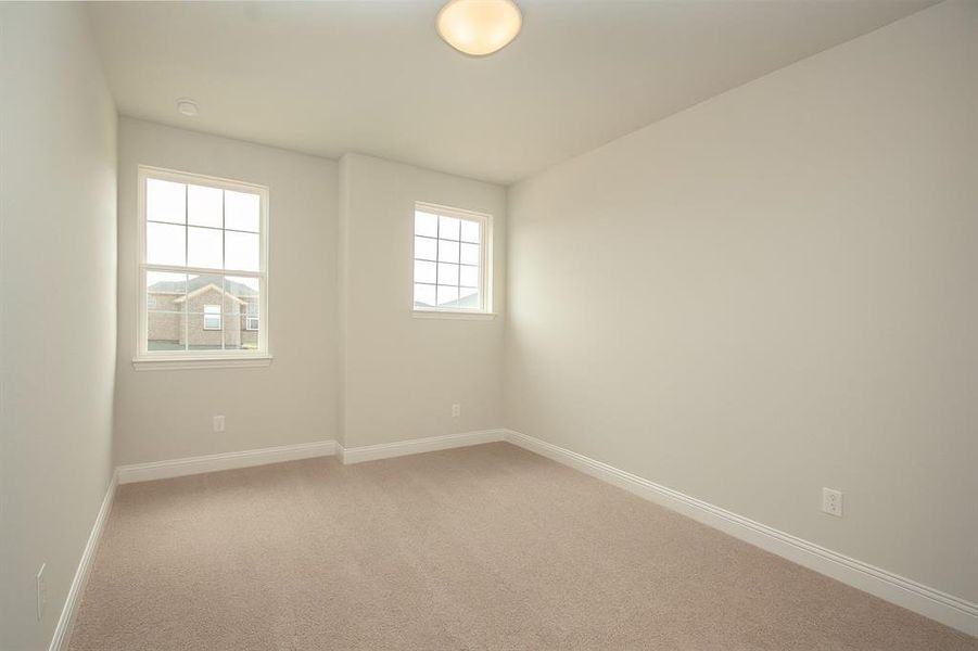 Spare room with light colored carpet and baseboards Spare room with light colored carpet and baseboards
