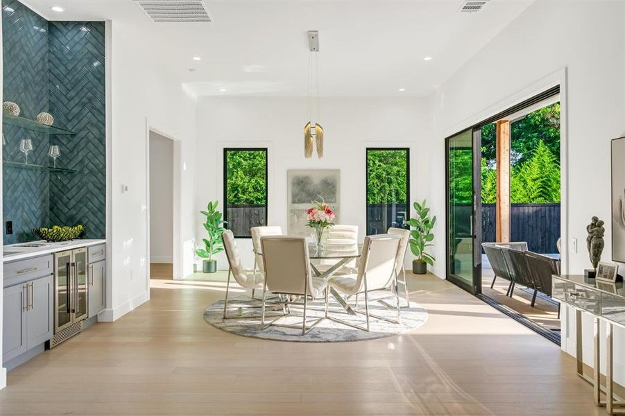 Dining space featuring wine cooler, light wood-type flooring, and recessed lighting
