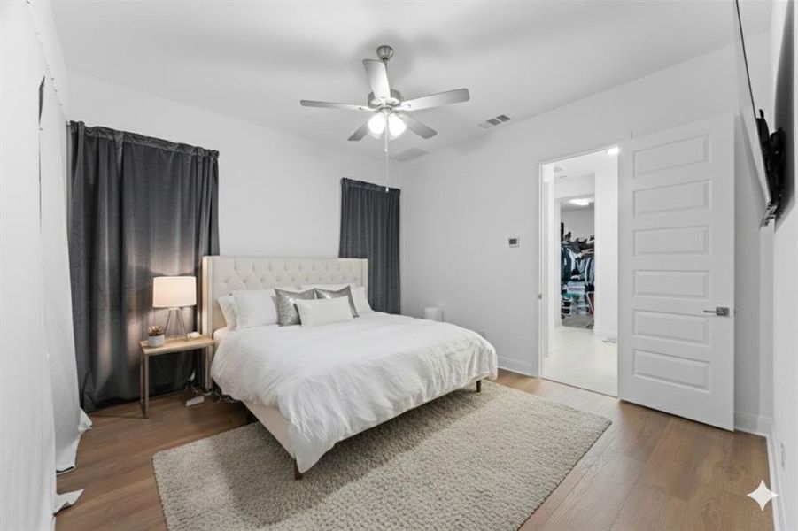 Primary Bedroom featuring light wood finished floors and a ceiling fan Primary Bedroom featuring light wood finished floors and a ceiling fan