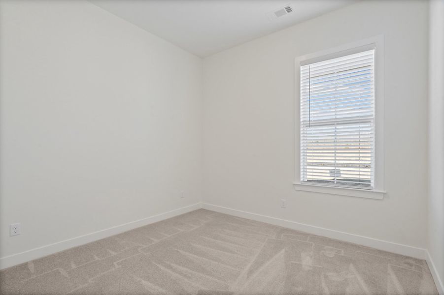 Spare room featuring light colored carpet and baseboards