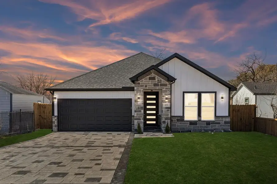 View of front of home featuring stone siding, driveway, an attached garage, board and batten siding, and roof with shingles