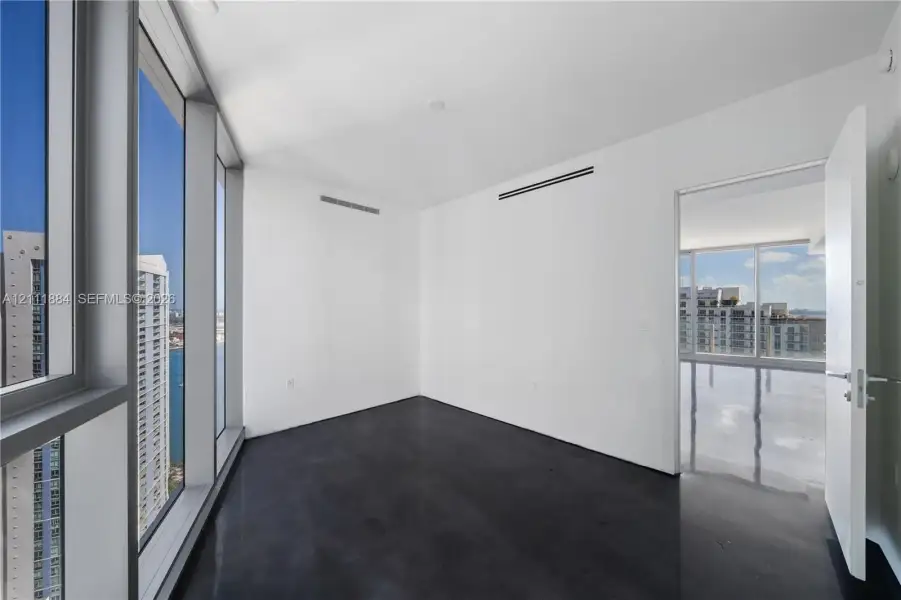 Floor-to-ceiling windows, polished concrete flooring, and high-rise urban scenery Floor-to-ceiling windows, polished concrete flooring, and high-rise urban scenery