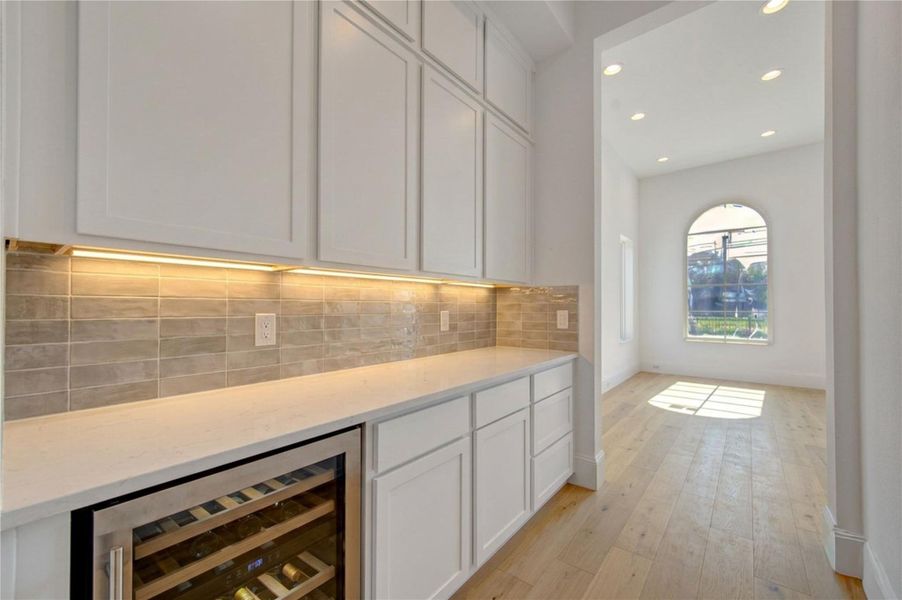 Virtual rendering of the stylish butler’s pantry featuring custom cabinetry, designer finishes, ample storage, and a built-in wine cooler—creating the perfect blend of function and sophistication for entertaining. Final finishes and selections subject to change by builder.