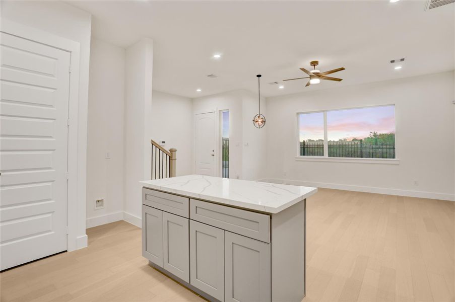 Central kitchen island with storage and quartz counters overlooking the open living space.