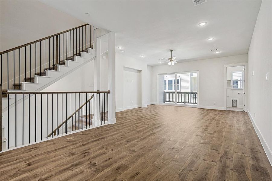 Unfurnished living room featuring wood finished floors, recessed lighting, a ceiling fan, and stairway