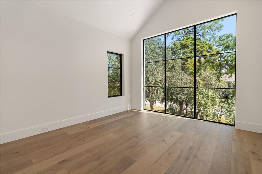 Secondary bedroom (3 up) with vaulted ceilings and floor-to-ceiling windows, creating the sensation of being nestled among the trees Secondary bedroom (3 up) with vaulted ceilings and floor-to-ceiling windows, creating the sensation of being nestled among the trees