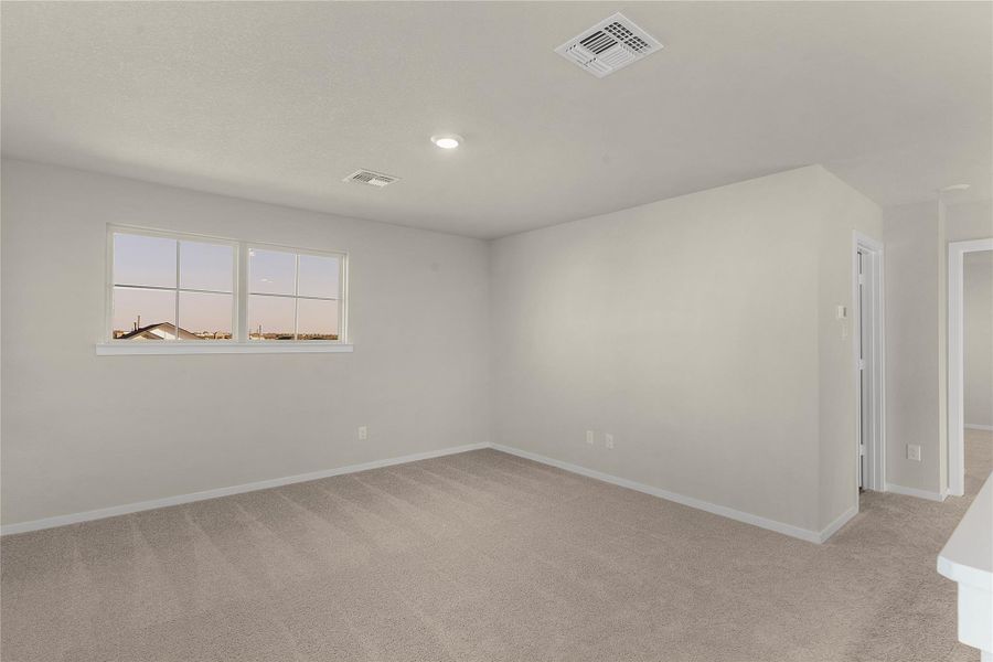 Unfurnished room featuring light carpet and baseboards