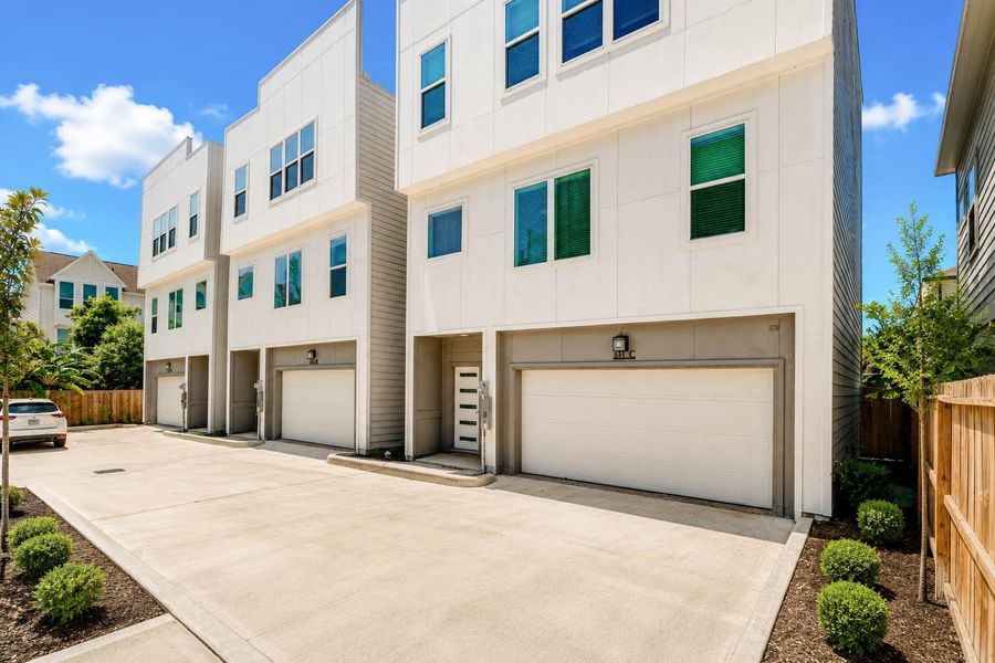 The private motor court creates an attractive arrival experience with generous driveway space, integrated garages, wood privacy fencing, and neatly manicured landscaping. Crisp modern architecture gives the residence a fresh, sophisticated presence. The private motor court creates an attractive arrival experience with generous driveway space, integrated garages, wood privacy fencing, and neatly manicured landscaping. Crisp modern architecture gives the residence a fresh, sophisticated presence.