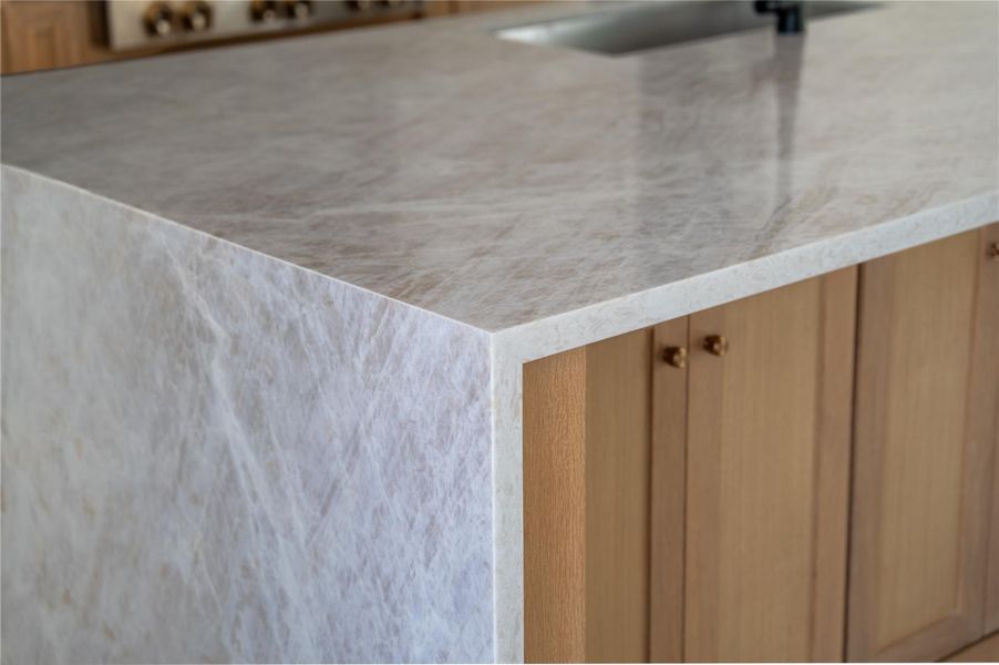 Custom cabinetry with Taj Mahal quartz countertops