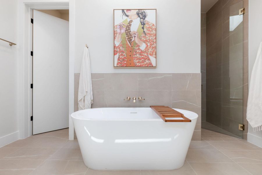 Full bath featuring tile patterned flooring, a soaking tub, and tile walls