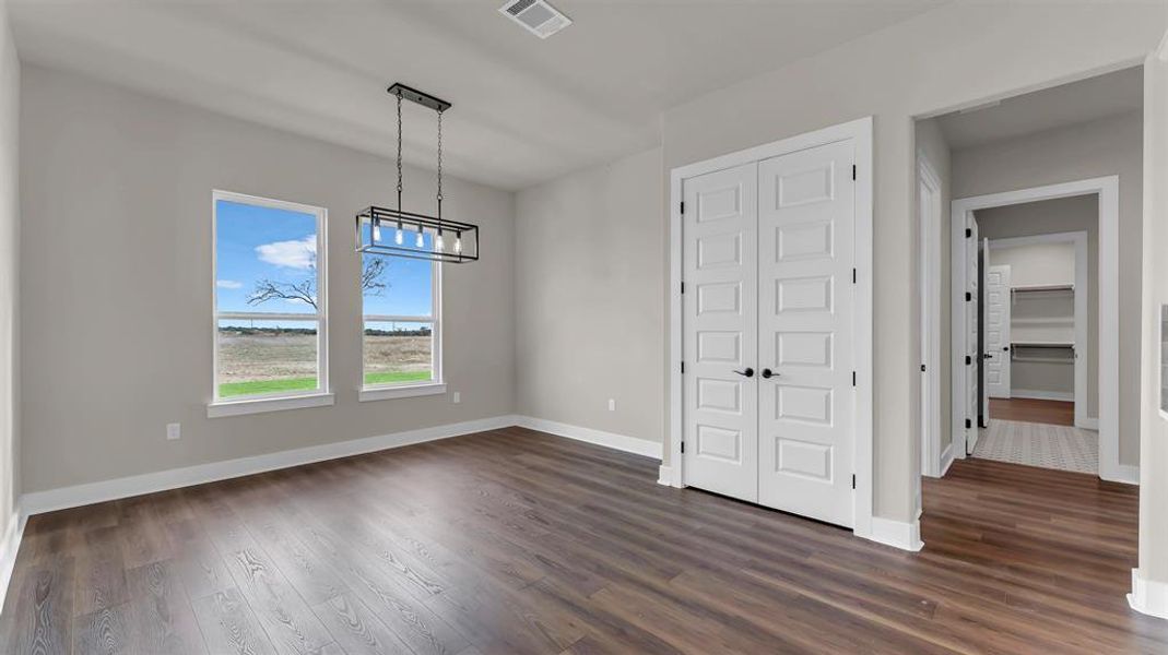 Rich wood floors and a modern linear chandelier highlight this versatile dining area. Rich wood floors and a modern linear chandelier highlight this versatile dining area.
