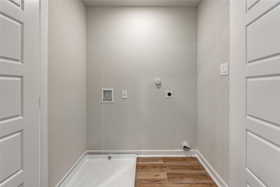 Laundry area featuring light wood finished floors, hookup for a gas dryer, washer hookup, and hookup for an electric dryer Laundry area featuring light wood finished floors, hookup for a gas dryer, washer hookup, and hookup for an electric dryer