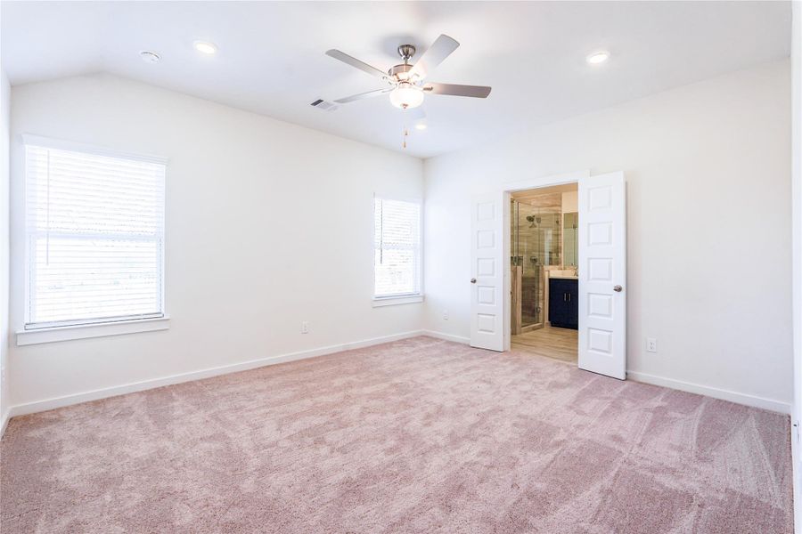 This bathroom features a modern design with a large vanity and dual sinks, complemented by a sleek blue cabinet. The shower-bath combo is finished with elegant beige tiles, and there's ample natural light.